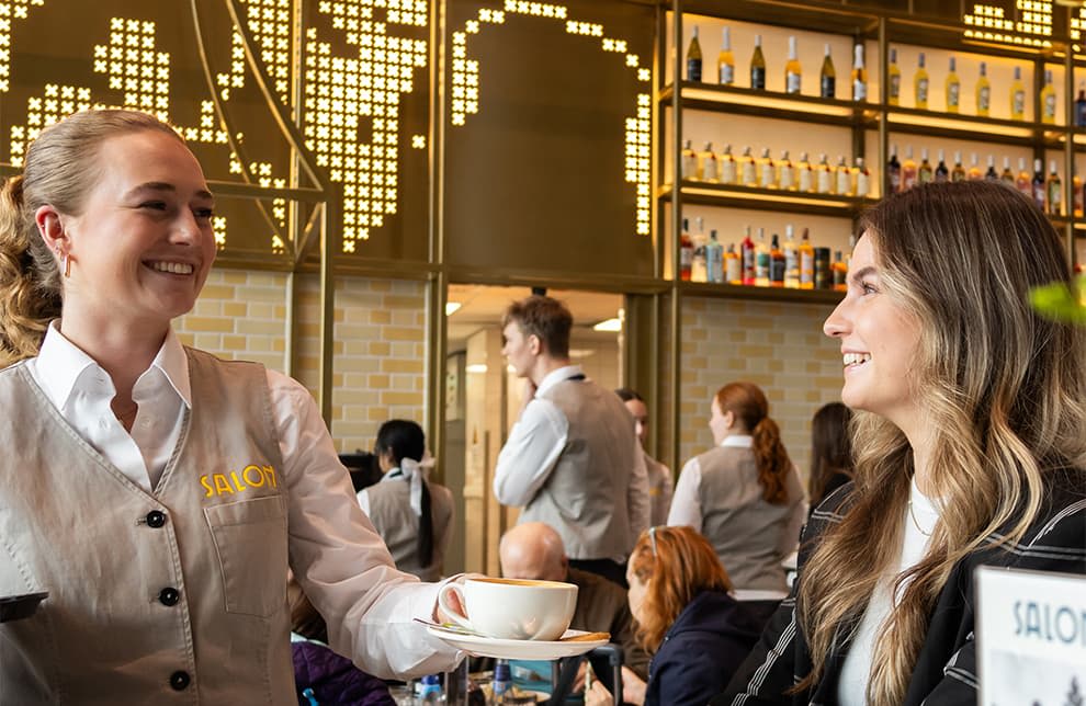 Photo shows a worker serving a customer at a cafe in Schiphol Airport