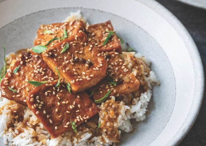 a picture of sticky coconut milk braised tofu on jasmine rice topped with Thai basil and sesame seeds