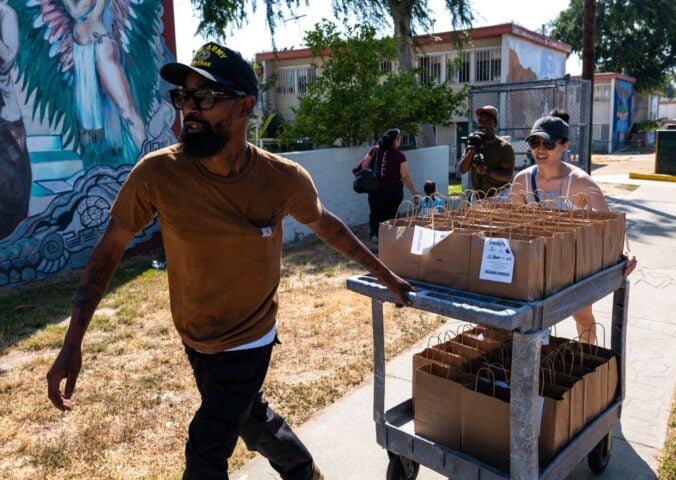 Vegan celebrity chef Supreme Dow wheeling a trolley full of plant-based meals