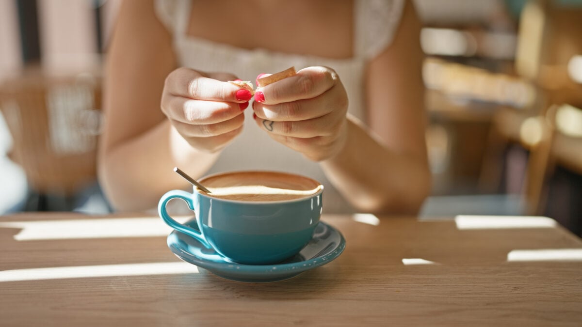 A woman putting sweetener in her coffee