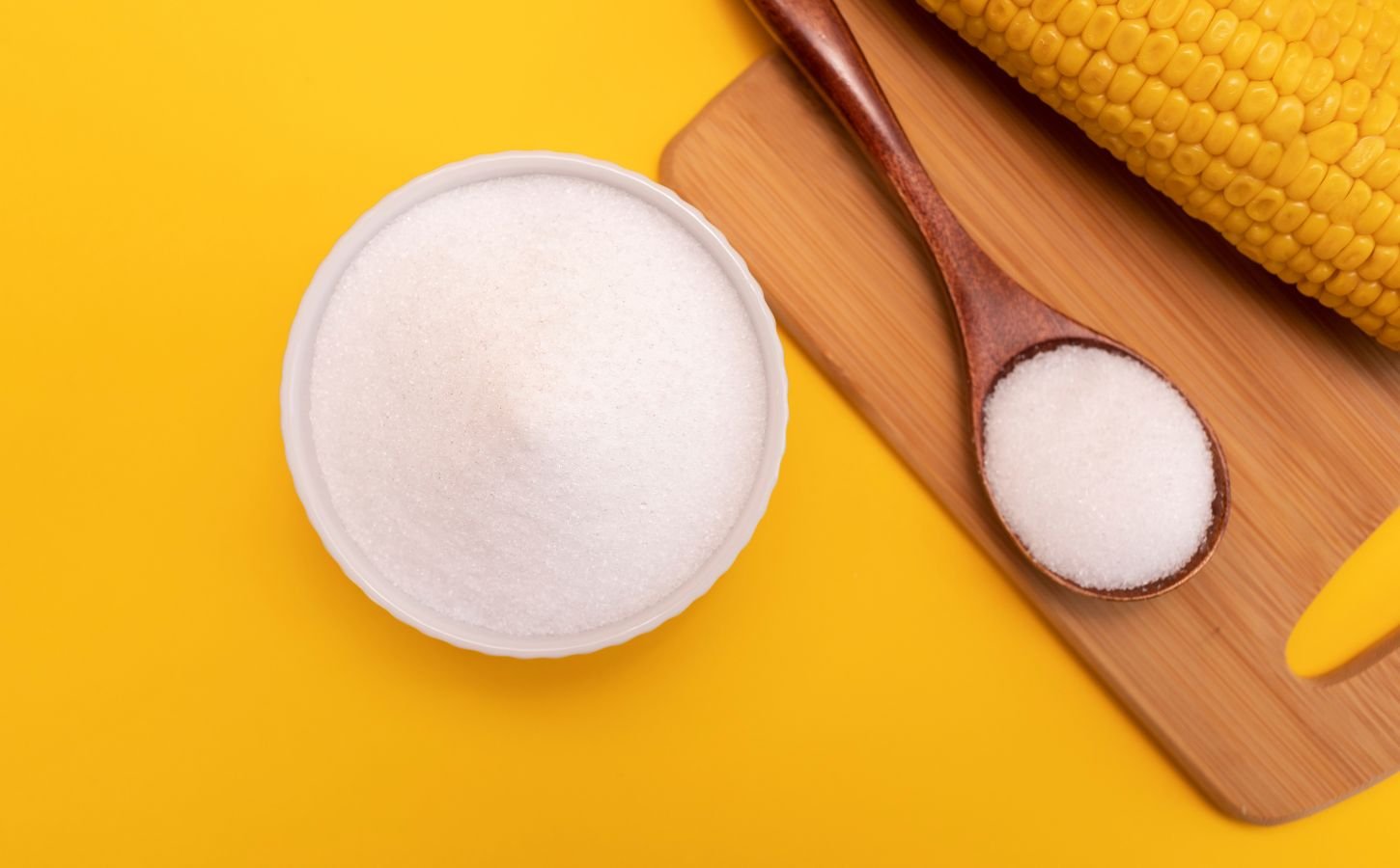 Artificial sweetener erythritol in a pot in front of a yellow background