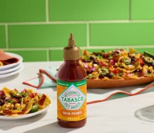 Photo shows a bottle of the new Tabasco hot sauce alongside plates of Mexican and Tex-Mex food