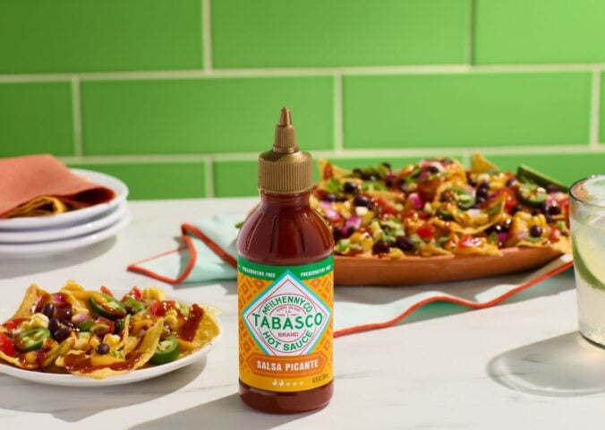 Photo shows a bottle of the new Tabasco hot sauce alongside plates of Mexican and Tex-Mex food