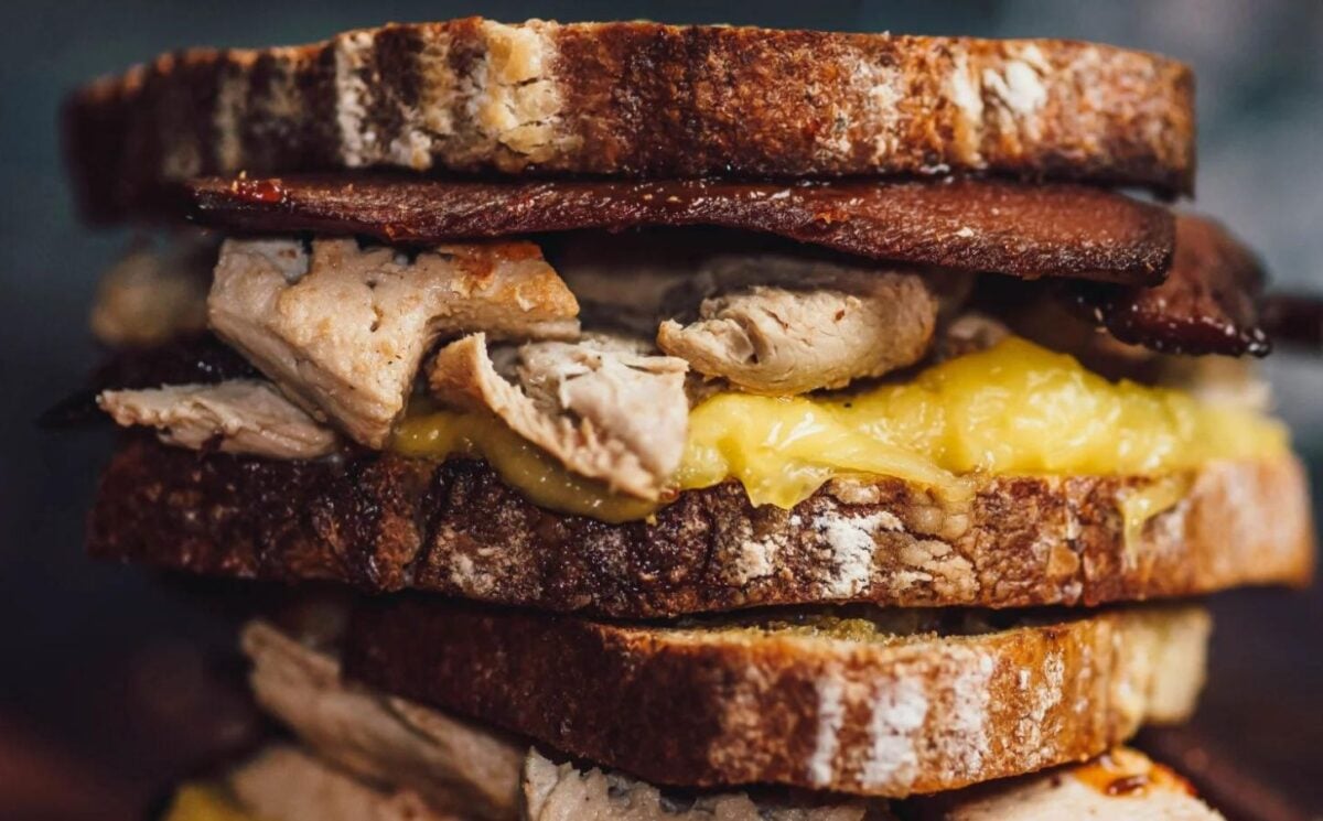 a picture of stacked vegan  bacon and chicken toasted sandwiches made with all vegan ingredients