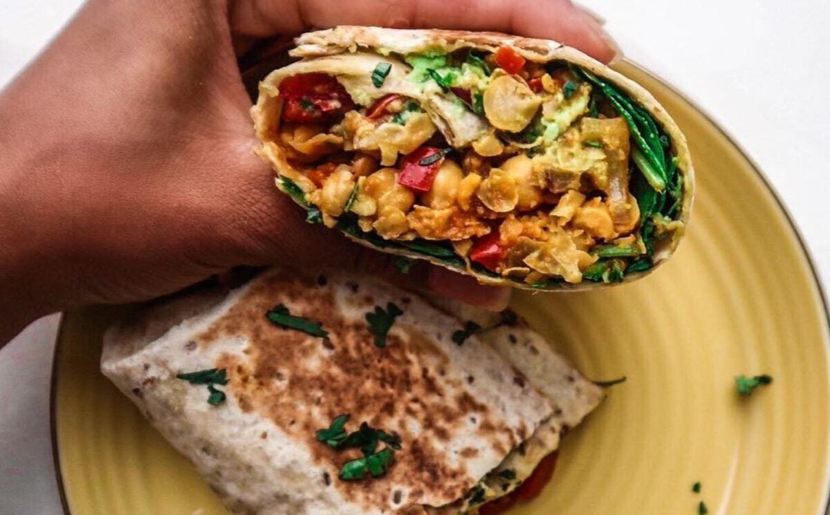 a picture of a vegan breakfast burrito which works well as a high protein breakfast idea, made with spinach, chickpea, and other ingredients