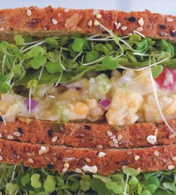 a picture of an apple and chickpea sandwich with sprouts perfect for a vegan packed lunch idea