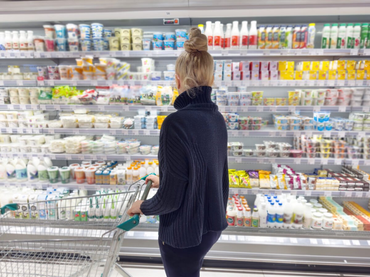 A woman looking for dairy-free cheese in a supermarket