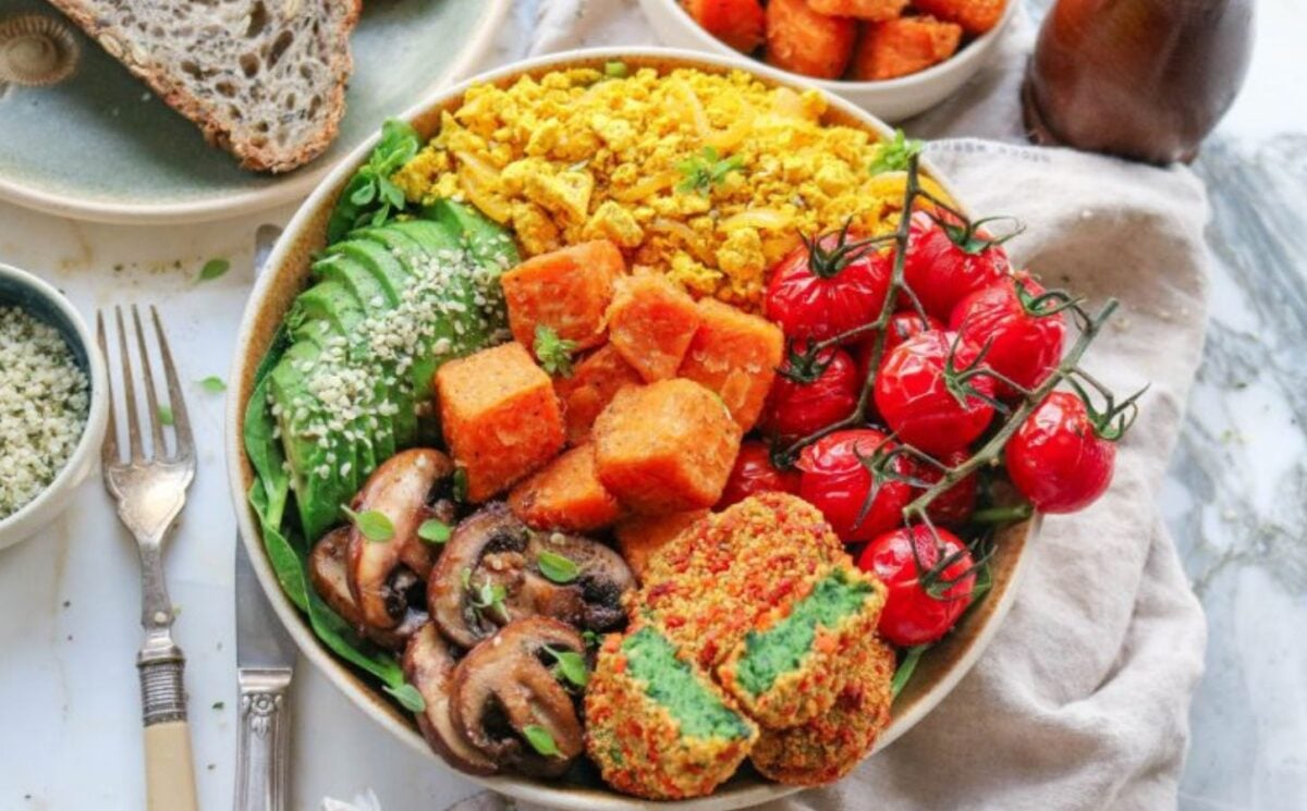 a picture of a veggie loaded brunch bowl with tofu, avocado, chestnut mushrooms, sweet potato, and cherry tomatoes