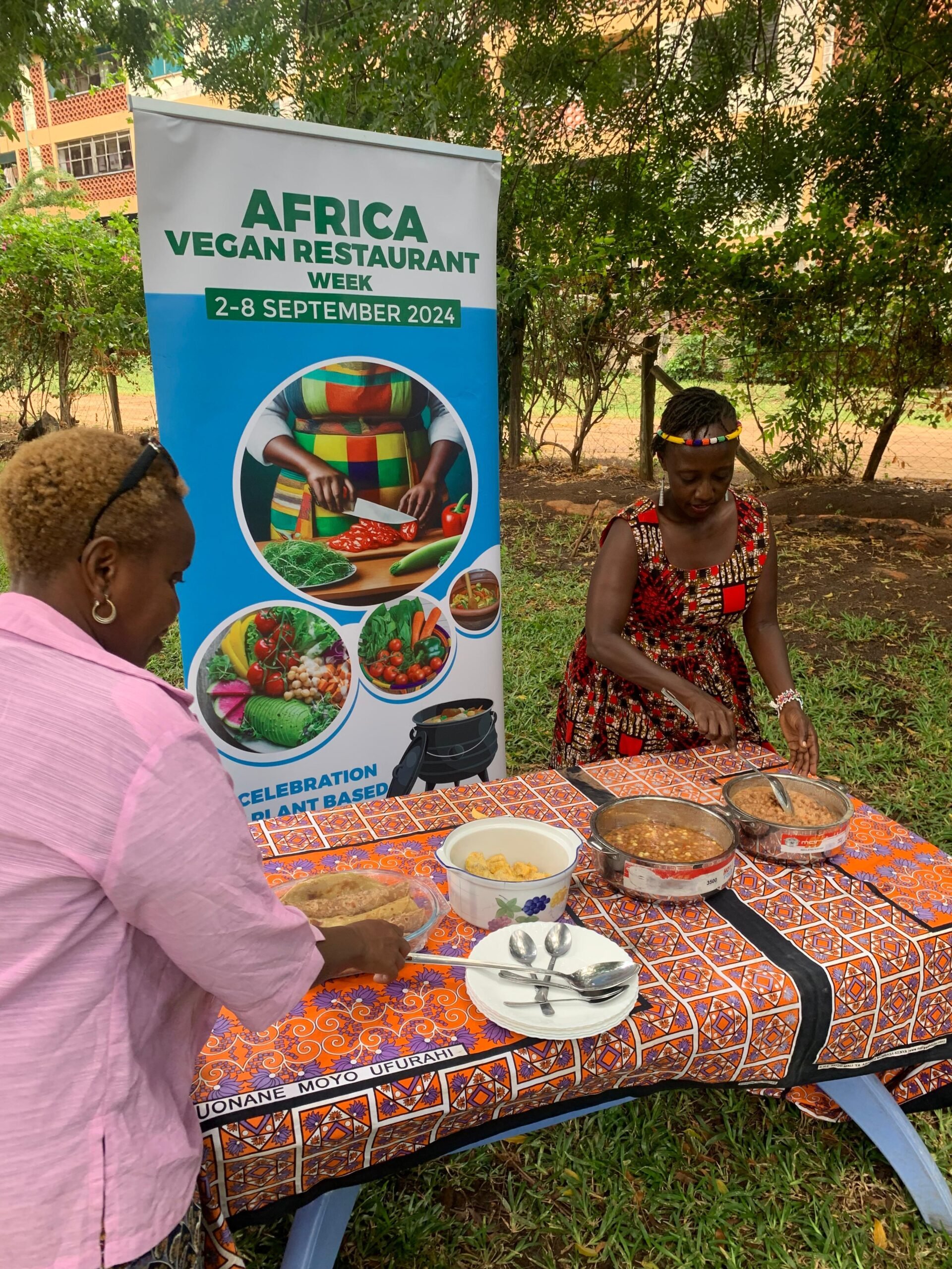 Photo shows Virginia Ruguru (left) working at a table of food with Mama Jo's restaurant owner Monalisa Wanguhu (right)