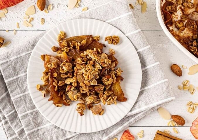 a picture of a plate of vegan apple crisp made with almond butter, apples, applesauce, cinnamon, and sugar