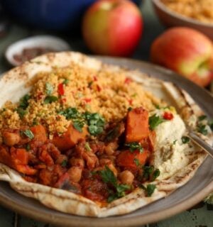 A plate of vegan apple, sweet potato, and chickpea tagine, a plant-based tagine recipe