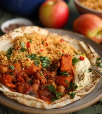 A plate of vegan apple, sweet potato, and chickpea tagine, a plant-based tagine recipe