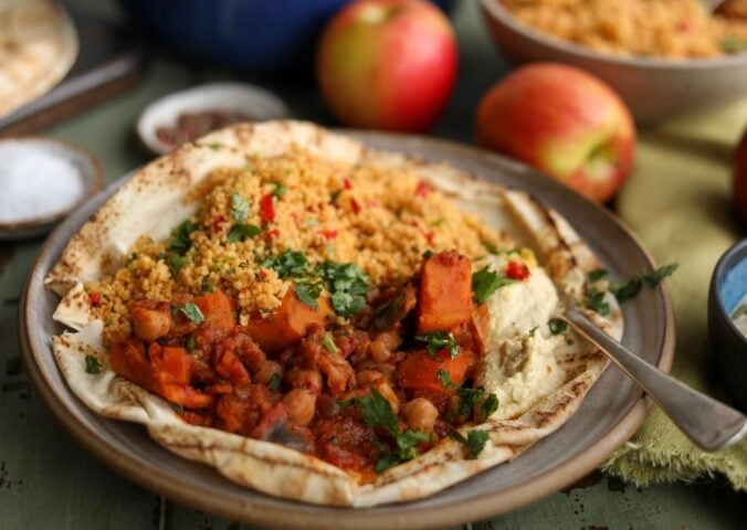 A plate of vegan apple, sweet potato, and chickpea tagine, a plant-based tagine recipe