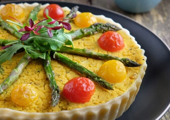 a picture of an asparagus, potato, and broccoli quiche made with chickpea flour and tomatoes