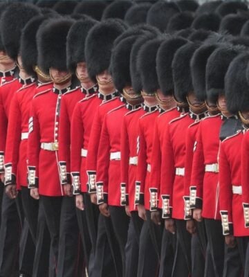 The King's Guard standing in a line wearing black fur caps, which are controversially made with real black bear fur