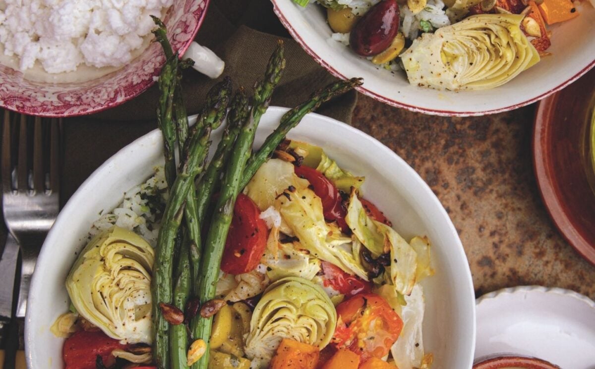 a picture of a cilantro veggie rice bowl topped with asparagus, artichoke, olives, cabbage, and tahini dressing