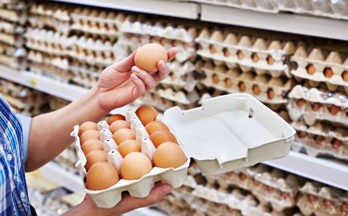 A person holding up an egg in a supermarket, many of whom have been recalled in the US due to a salmonella outbreak