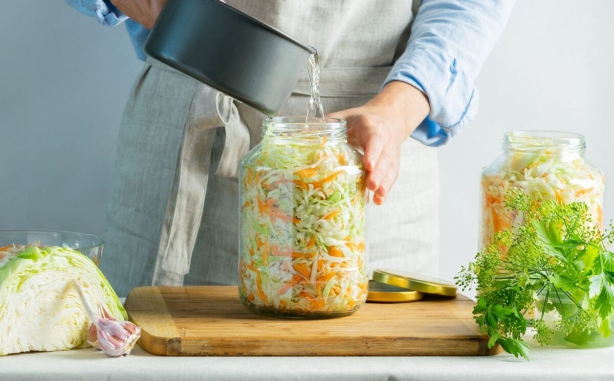 A woman making sauerkraut, a fermented food that benefits gut health