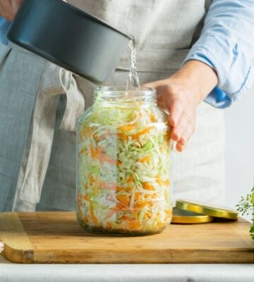 A woman making sauerkraut, a fermented food that benefits gut health