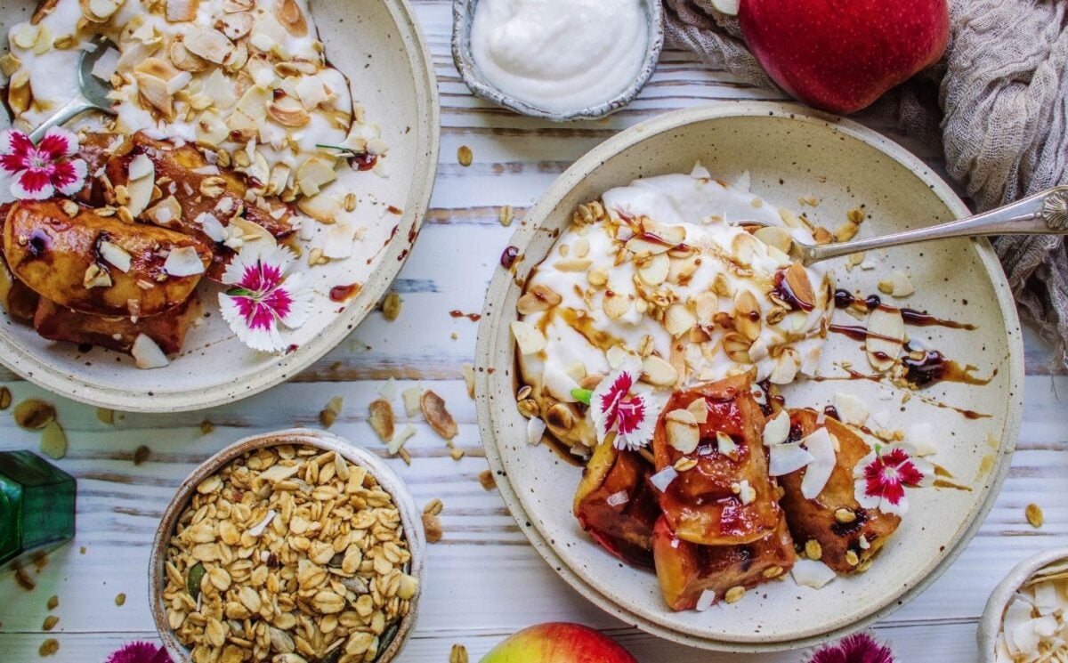 A vegan grilled apple dish served with coconut cream and flaked almonds