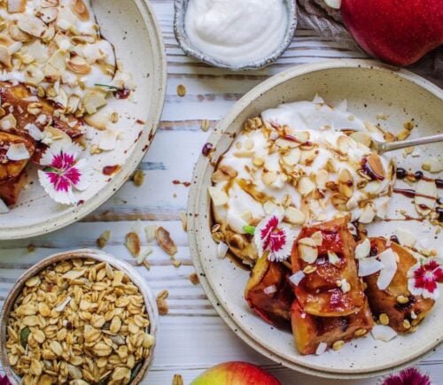 A vegan grilled apple dish served with coconut cream and flaked almonds