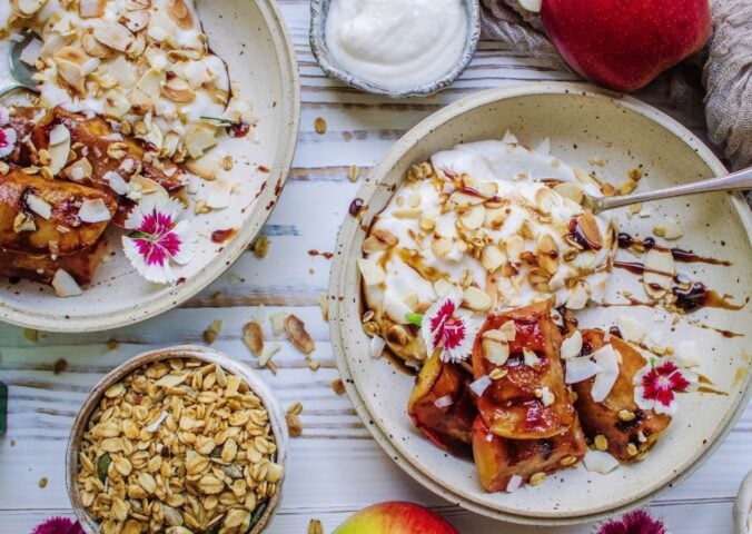 A vegan grilled apple dish served with coconut cream and flaked almonds