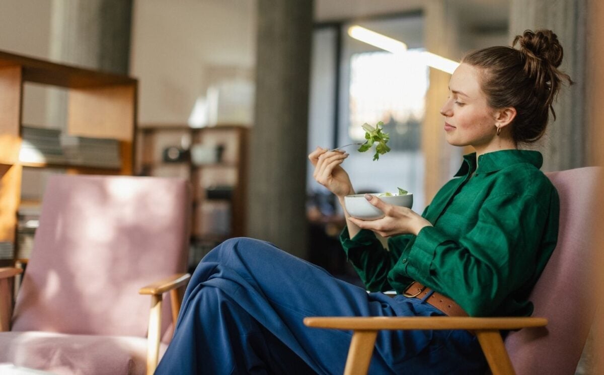 A woman eating a bowl of leafy salad including watercress, which is sometimes regarded as the healthiest vegetable