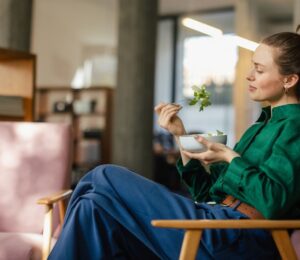 A woman eating a bowl of leafy salad including watercress, which is sometimes regarded as the healthiest vegetable