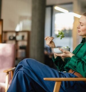 A woman eating a bowl of leafy salad including watercress, which is sometimes regarded as the healthiest vegetable