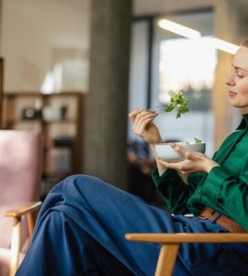 A woman eating a bowl of leafy salad including watercress, which is sometimes regarded as the healthiest vegetable