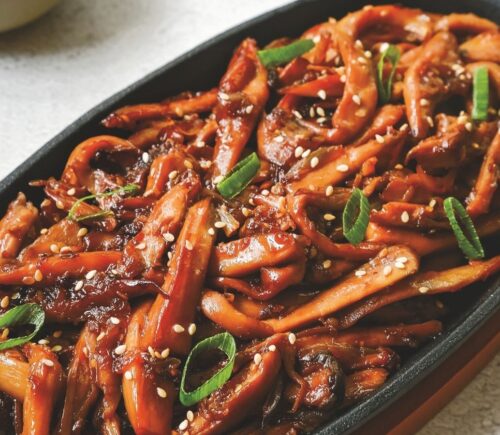 a picture of Korean bulgogi mushrooms made with king oyster mushrooms, and served with rice and vegan kimchi