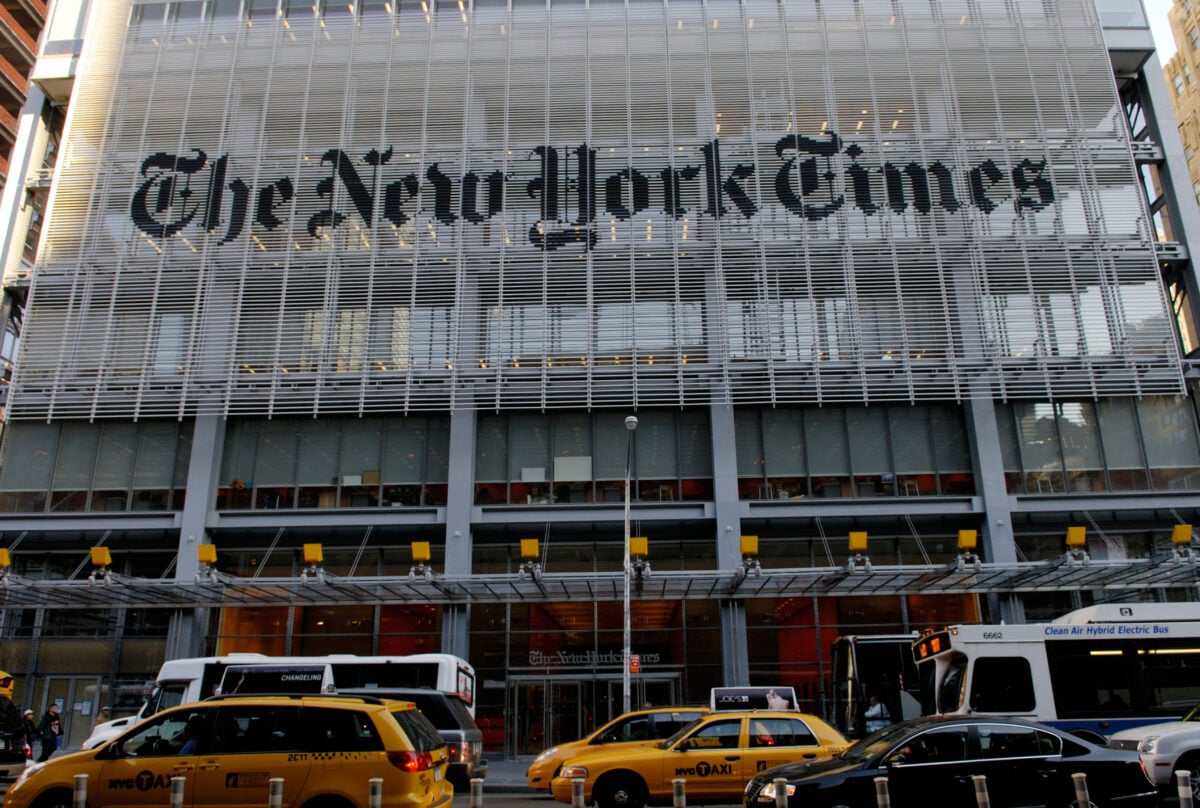 Photo shows the New York Times building in new York City with traffic passing in front