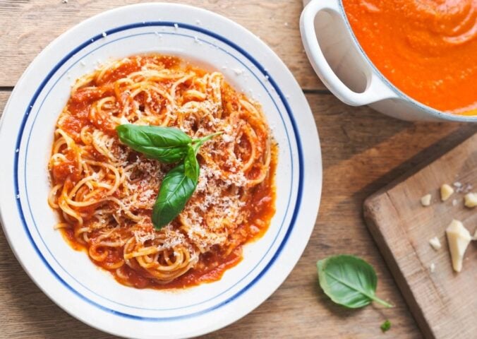 a picture of Nonna's pasta with tomato sauce topped with basil and vegan Parmesan