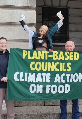 Campaigners from Plant-Based Councils celebrating outside the town hall