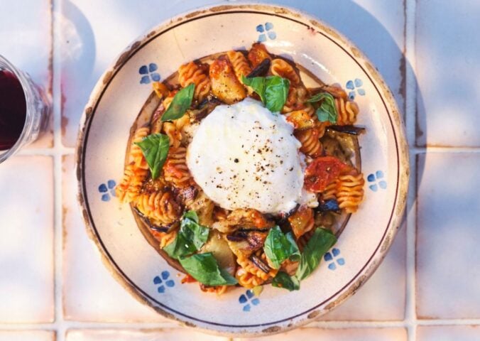 a picture of pasta alla norma or aubergine pasta topped with vegan burrella