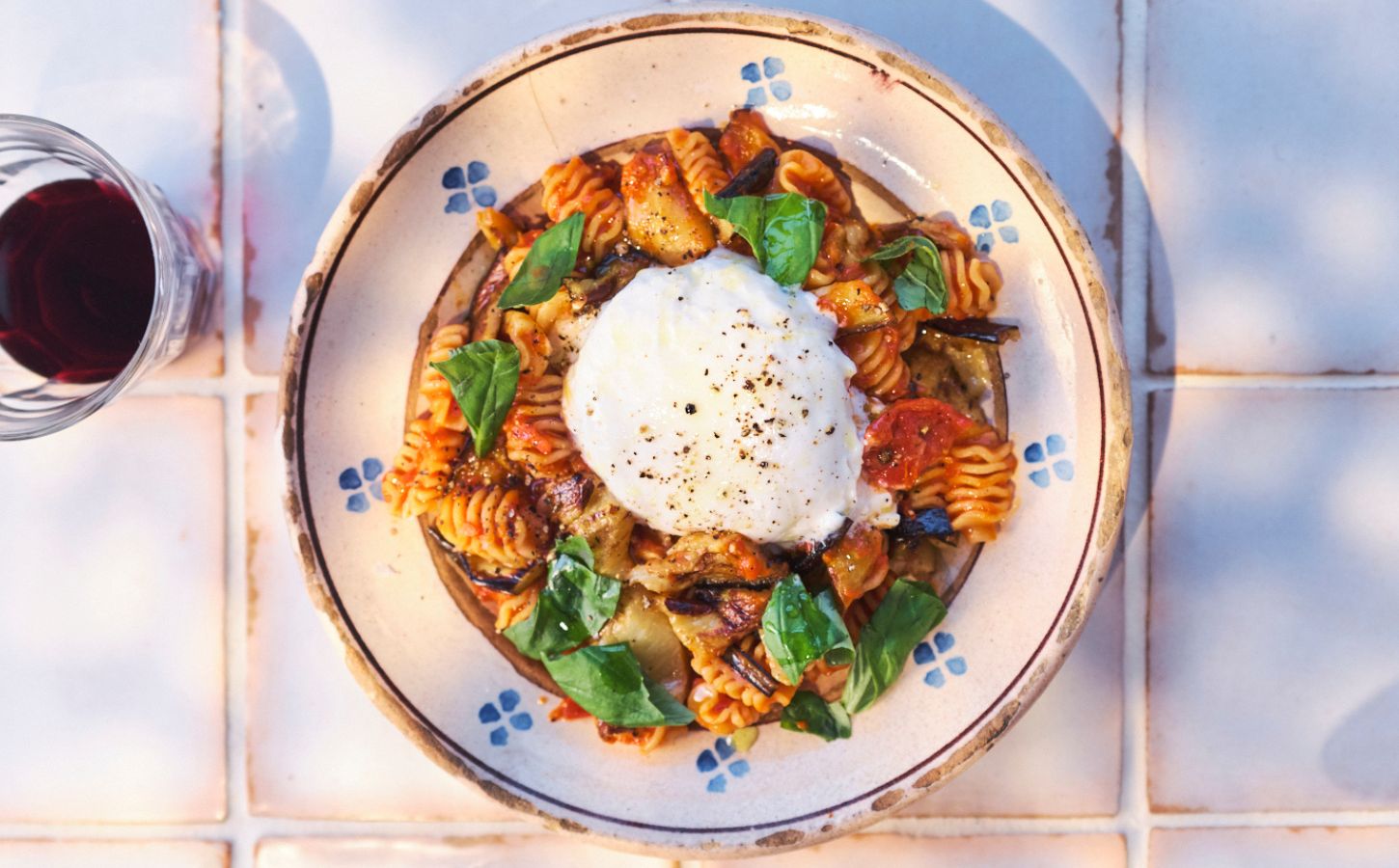 a picture of pasta alla norma or aubergine pasta topped with vegan burrella