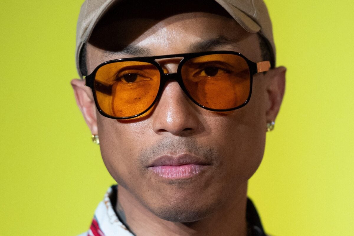 A close-up shot of Pharrell Williams' face in front of a yellow background