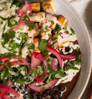 a picture of a protein packed bowl filled with quinoa, black beans, smoky tofu, and cabbage