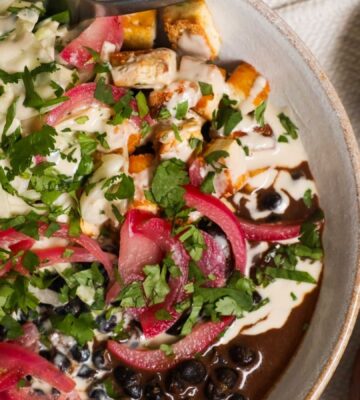 a picture of a protein packed bowl filled with quinoa, black beans, smoky tofu, and cabbage