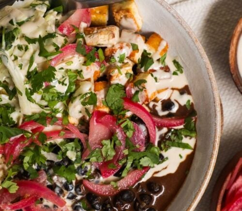 a picture of a protein packed bowl filled with quinoa, black beans, smoky tofu, and cabbage