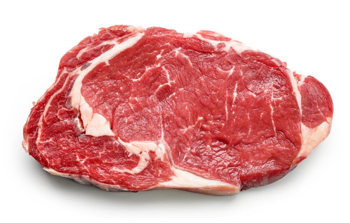 Photo shows a raw beef steak on a white background