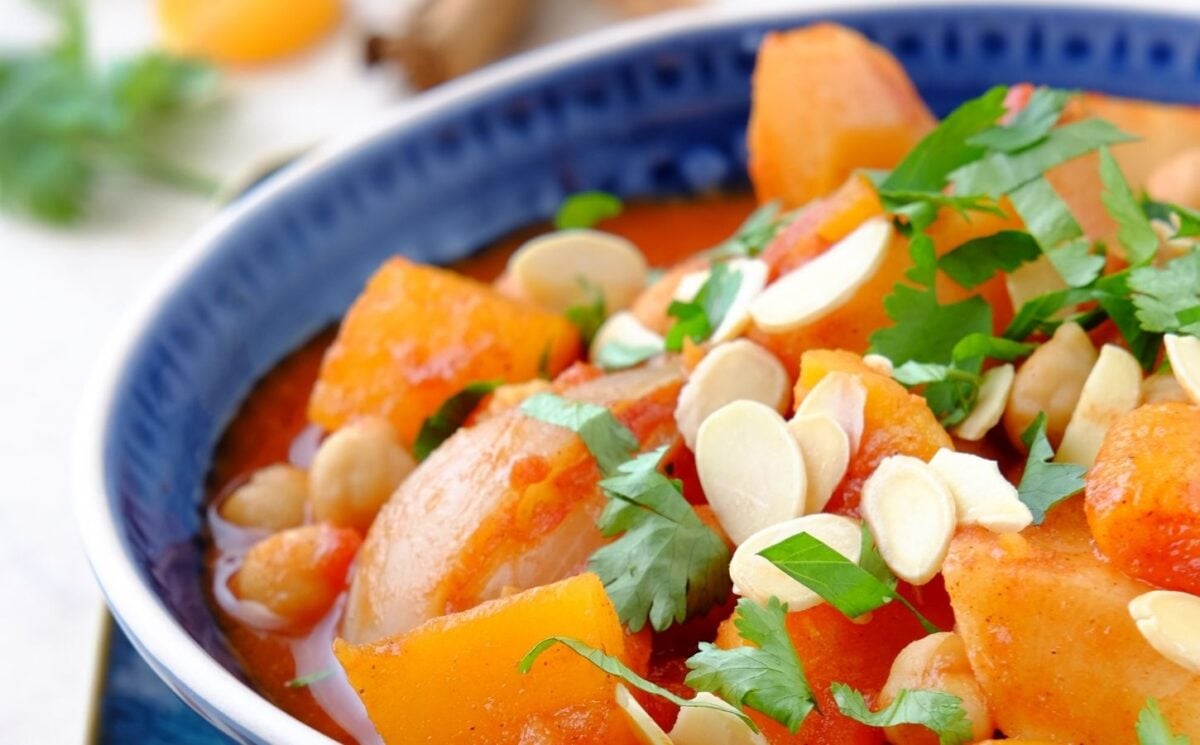 a picture of a seasonal root vegetable tagine topped with almonds and coriander