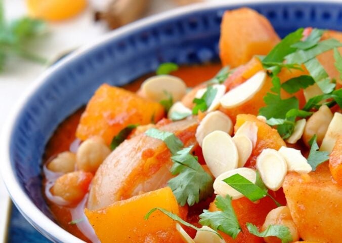 a picture of a seasonal root vegetable tagine topped with almonds and coriander