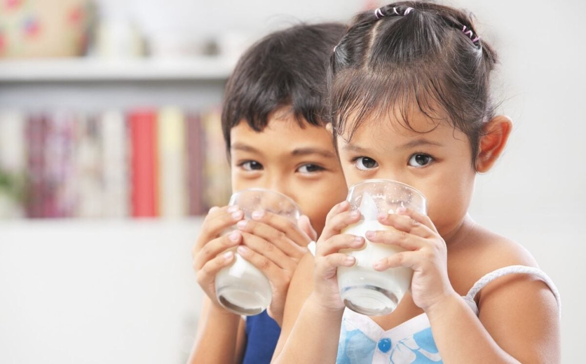 Two children drinking dairy milk in line with USDA dietary guidelines