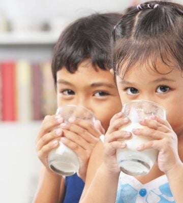 Two children drinking dairy milk in line with USDA dietary guidelines