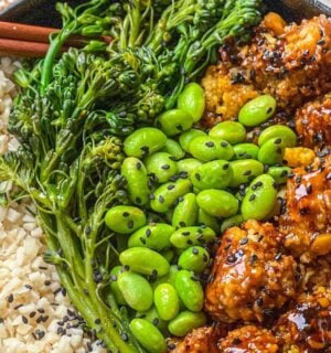 a picture of a tasty-as-takeout teriyaki cauliflower bowl made with heart of palm rice, teriyaki cauliflower, edamame, and broccolini