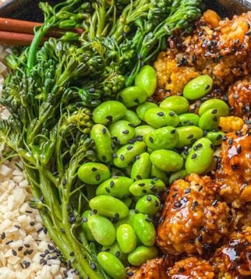 a picture of a tasty-as-takeout teriyaki cauliflower bowl made with heart of palm rice, teriyaki cauliflower, edamame, and broccolini