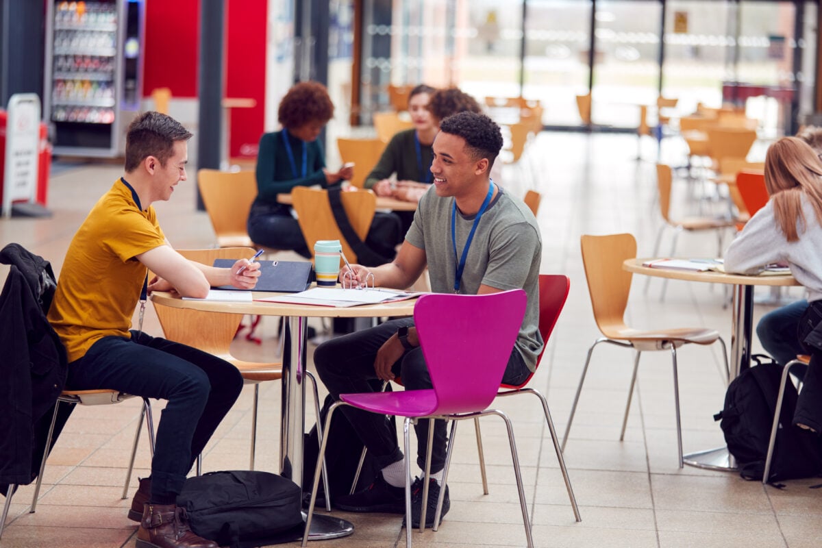 Two students sitting and laughing in a university cafeteria