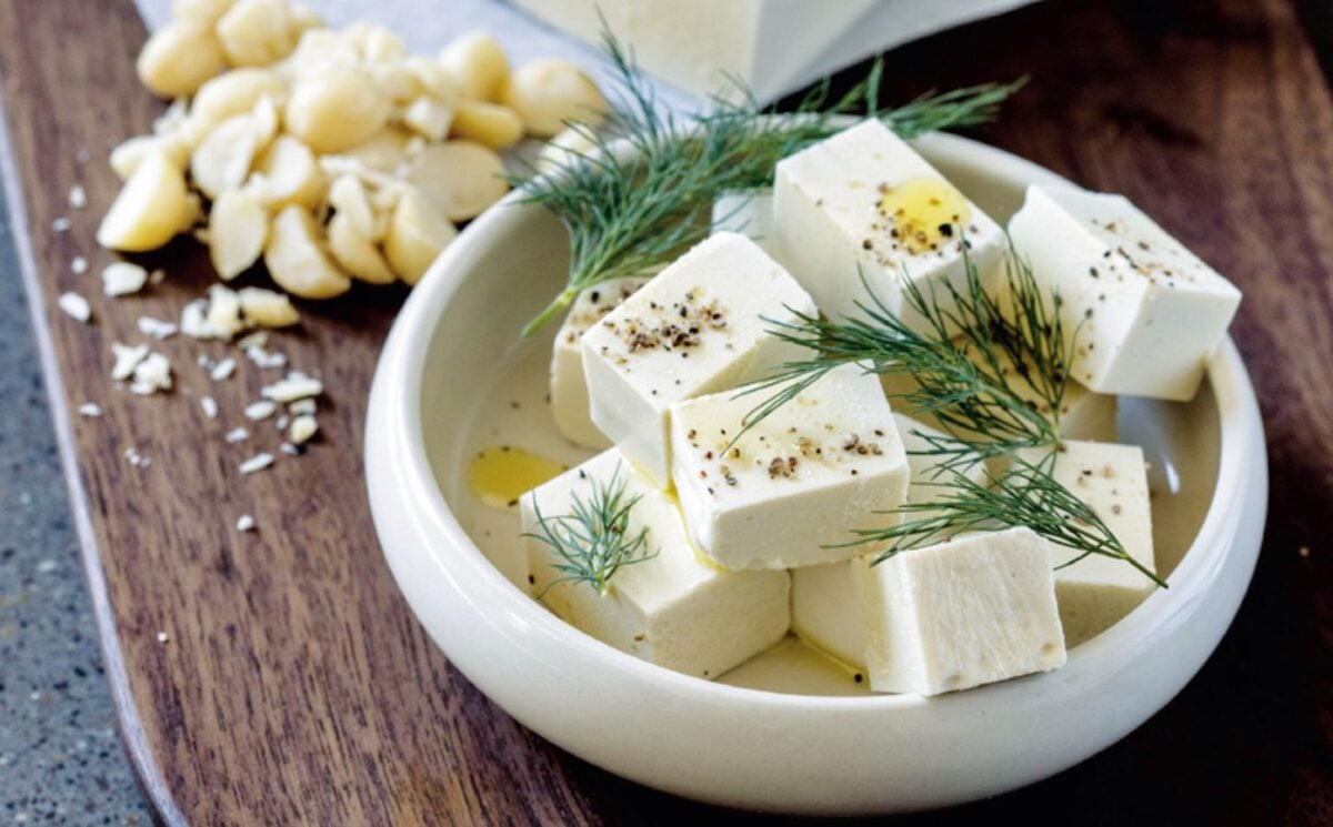 A white bowl filled with homemade macadamia feta, a homemade vegan cheese recipe cooked from scratch