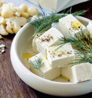 A white bowl filled with homemade macadamia feta, a homemade vegan cheese recipe cooked from scratch